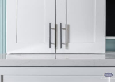 White shaker-style built-in cabinet with brushed metal bar pulls and quartz countertop in this Voorhees basement remodel.