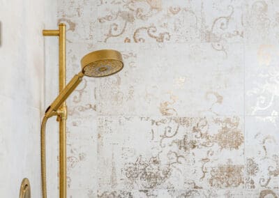 Brushed brass shower head and handheld fixture with decorative tile in Mullica Hill bathroom remodel