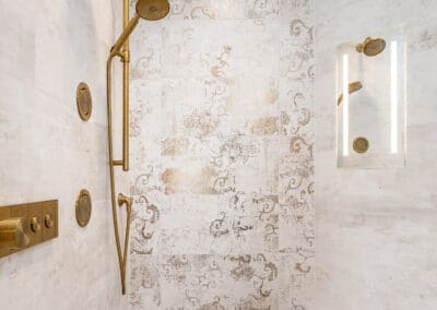 Brushed brass shower fixtures with decorative tile and bench in Mullica Hill bathroom remodel