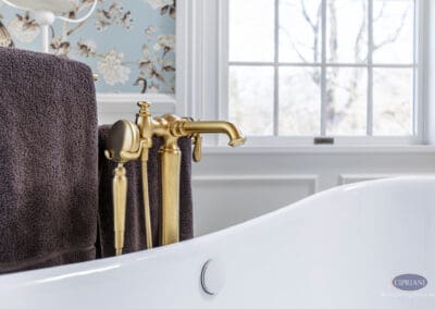 Brushed brass freestanding tub filler beside white clawfoot tub in Mullica Hill bathroom remodel