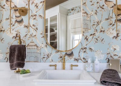 White bathroom vanity with brass fixtures and blue chinoiserie wallpaper in Mullica Hill remodel