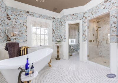 Freestanding soaking tub with brass fixtures and glass shower in elegant Mullica Hill bathroom remodel