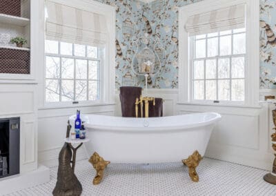 Freestanding clawfoot tub with brass fixtures and bird wallpaper in Mullica Hill bathroom remodel