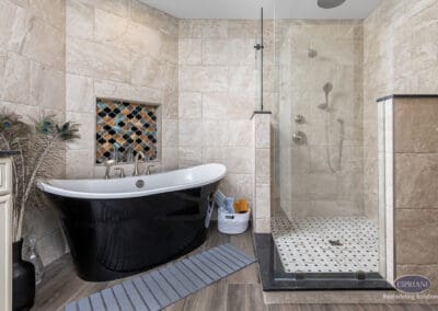 Freestanding black soaking tub with tile niche and glass walk-in shower in Wenonah bathroom remodel